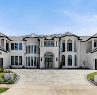 a white and black home with a driveway and garage
