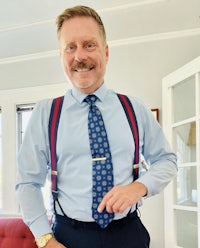 a man in a blue shirt and suspenders