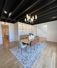 a dining room with hardwood floors and black ceilings