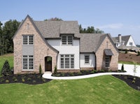 an aerial view of a brick home in a grassy area